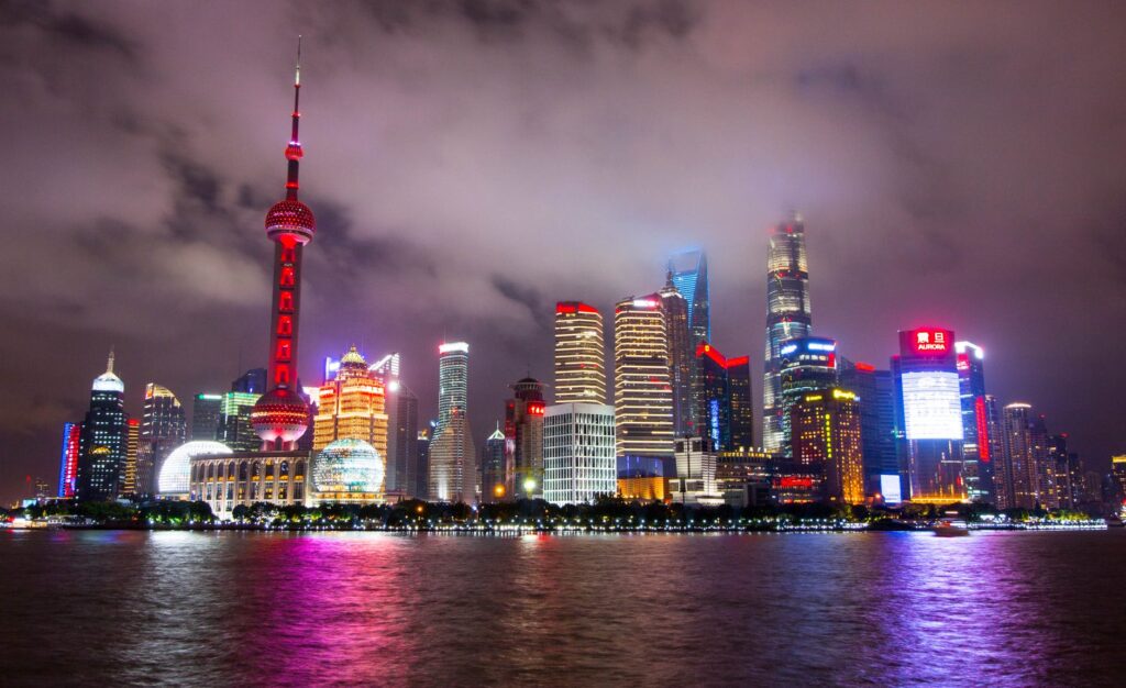 lighted buildings during nighttime near body of water